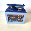 A blue resin piggy bank shaped like Godzilla featuring a small figure and an eye detail.