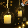 A glass jar candle with a glowing white flame is suspended, next to a hand holding a remote control.