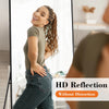 A woman is reflected in a full length arched wall mirror showing her outfit and face.