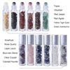A collection of ten glass bottles filled with various semi-precious stone roller balls including topaz, obsidian, jasper, aga