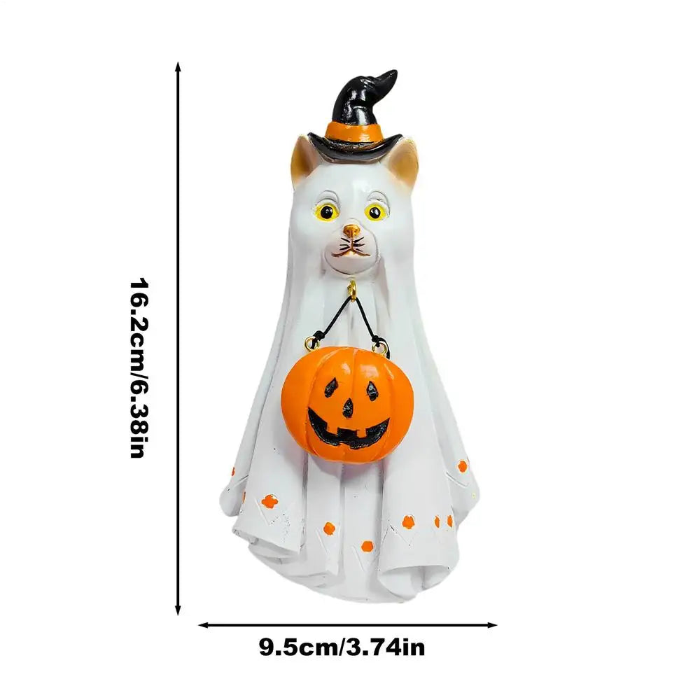 A white ghost figurine with a black witch hat and an orange carved pumpkin decoration.