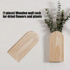 A light wood wall rack for displaying dried flowers and plants.