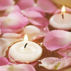 Pink rose petals surround glowing white floating candles for romantic home décor
