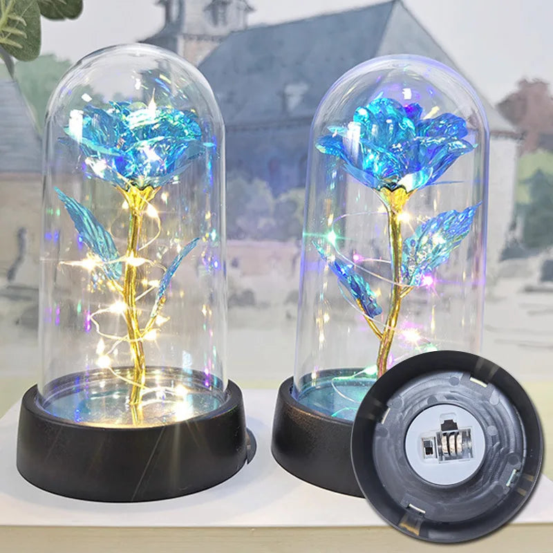 A glass dome featuring an eternal rose plant illuminated by a bright LED light.