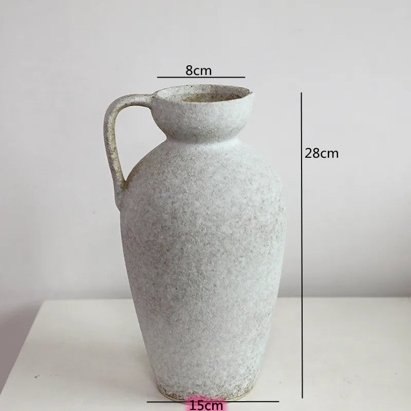 A tall, light gray ceramic vase with a handle, shown against a white background.