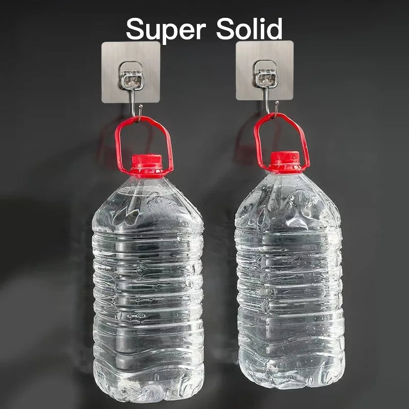 Two clear plastic water bottles hanging from metal wall hooks for home organization