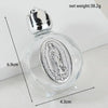 A clear glass bottle containing a silver-colored figurine, with dimensions and net weight indicated.
