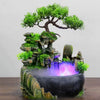 Resin waterfall desktop fountain with LED lighting featuring a mossy rock landscape and glowing purple water.