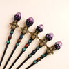 A set of five amethyst bee crystal scepters with gold accents and green beads.