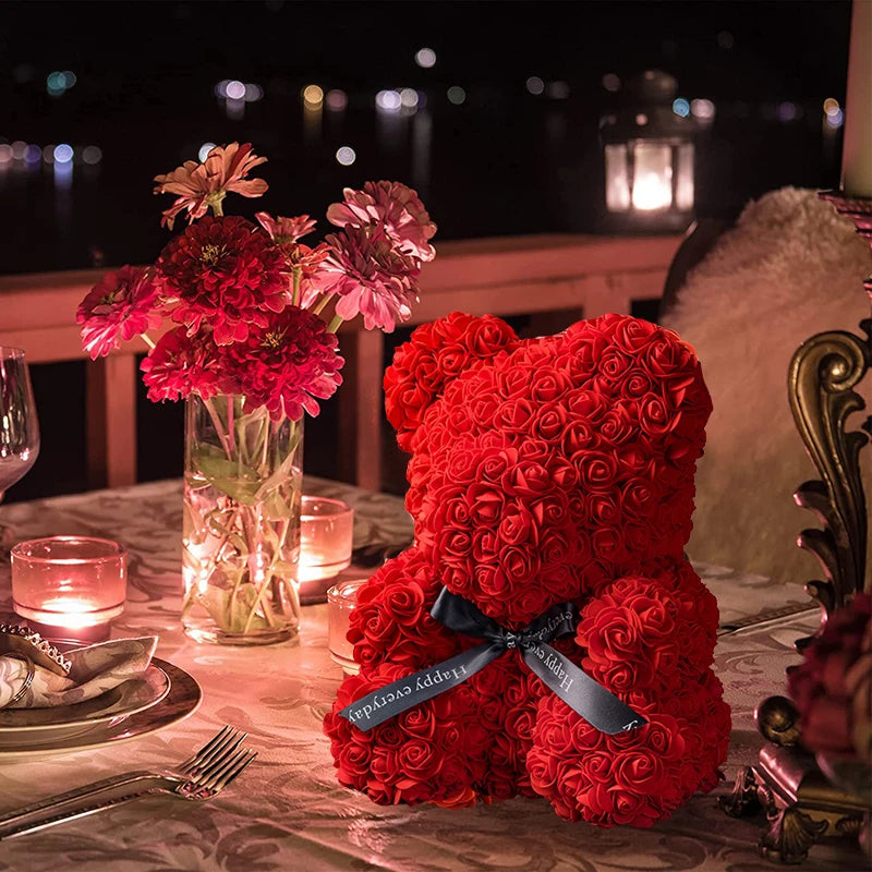 Un ours rose en peluche avec un ruban noir et une décoration lumineuse LED sur une table.