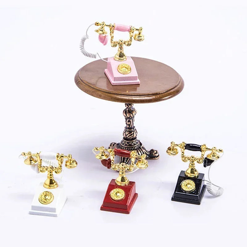 A vintage rotary desk phone miniature decor with gold and pink accents displayed on a wooden stand.