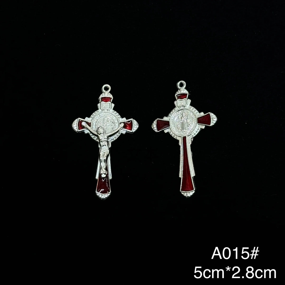 A pair of silver crucifix pendants featuring red enamel on a white background.