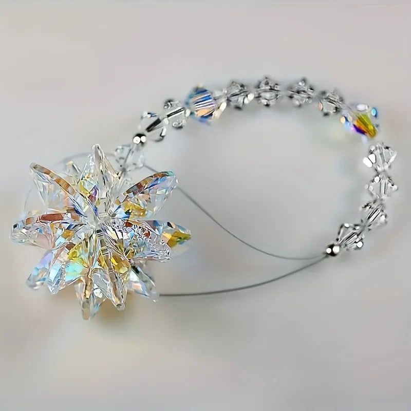 A sparkling crystal star suncatcher ornament attached to a silver-toned wire bracelet.