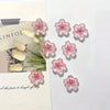 Pink cherry blossom fridge magnets arranged on a white background with floral text.