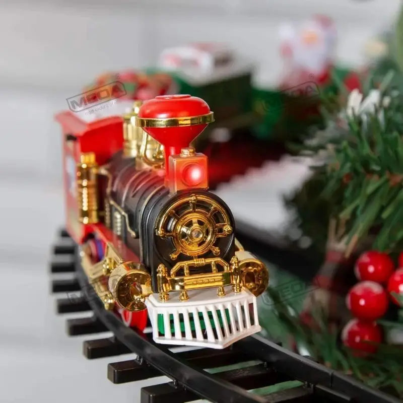 A detailed battery-powered railway train toy with red and black body, gold accents, and a white grille on a track.