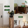 A collection of vintage humorous lowrider metal tin signs displayed on a white wall and wooden cabinet.