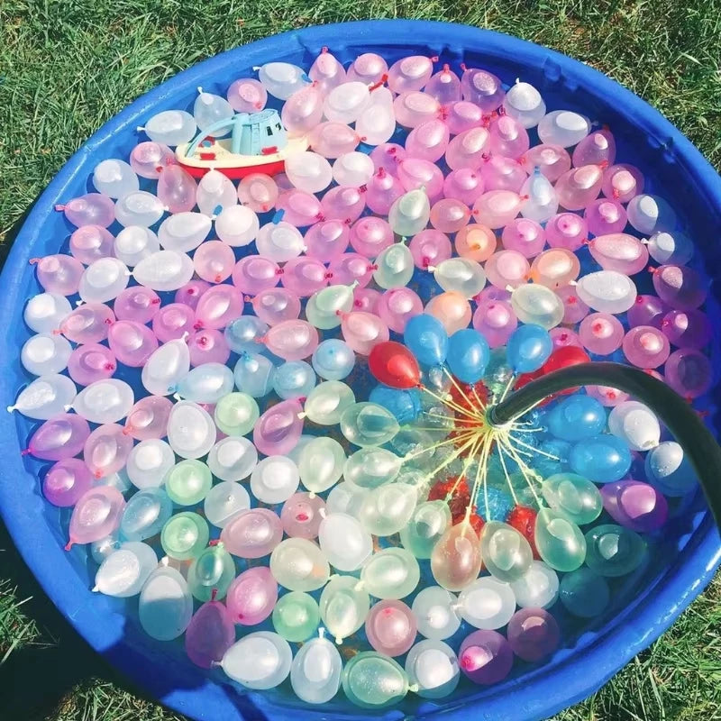 A blue bowl filled with numerous water balloons in various shades of pink, purple, and green.
