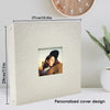 A personalized linen cover for a scrapbook album featuring a photograph, displayed next to a clock.