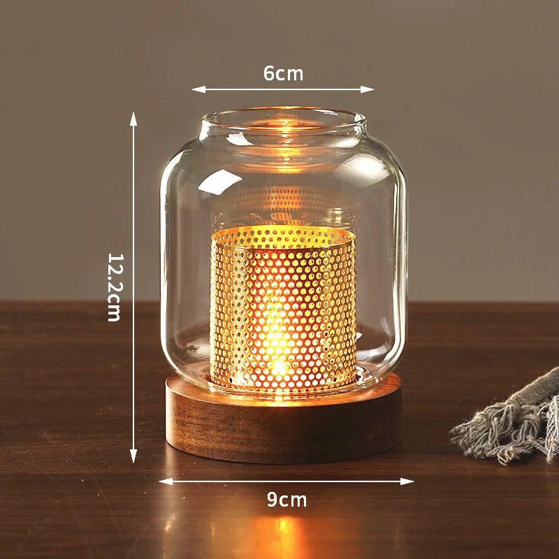 A vintage wooden candle lantern with a glass cover and a glowing candle inside, resting on a wooden surface.