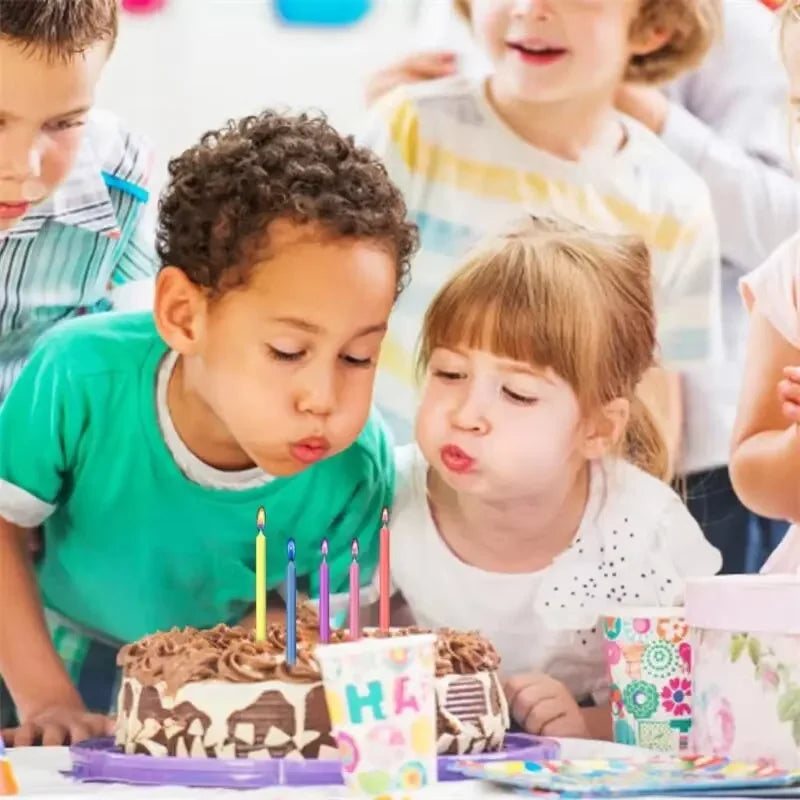 A child is decorating a cake with vibrant flame decorative candles in a bright indoor setting.