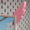 Pink 3D printed LED monitor wing decorations displayed against a patterned background.