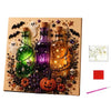 A framed diamond painting featuring three glass bottles with Halloween themes like skulls and spiders.