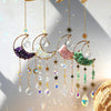 A set of gold dreamcatchers featuring crescent moon shapes and various colored crystals like purple, white, pink, and green.