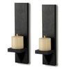 A pair of black wooden wall candle holders with cream-colored candles.