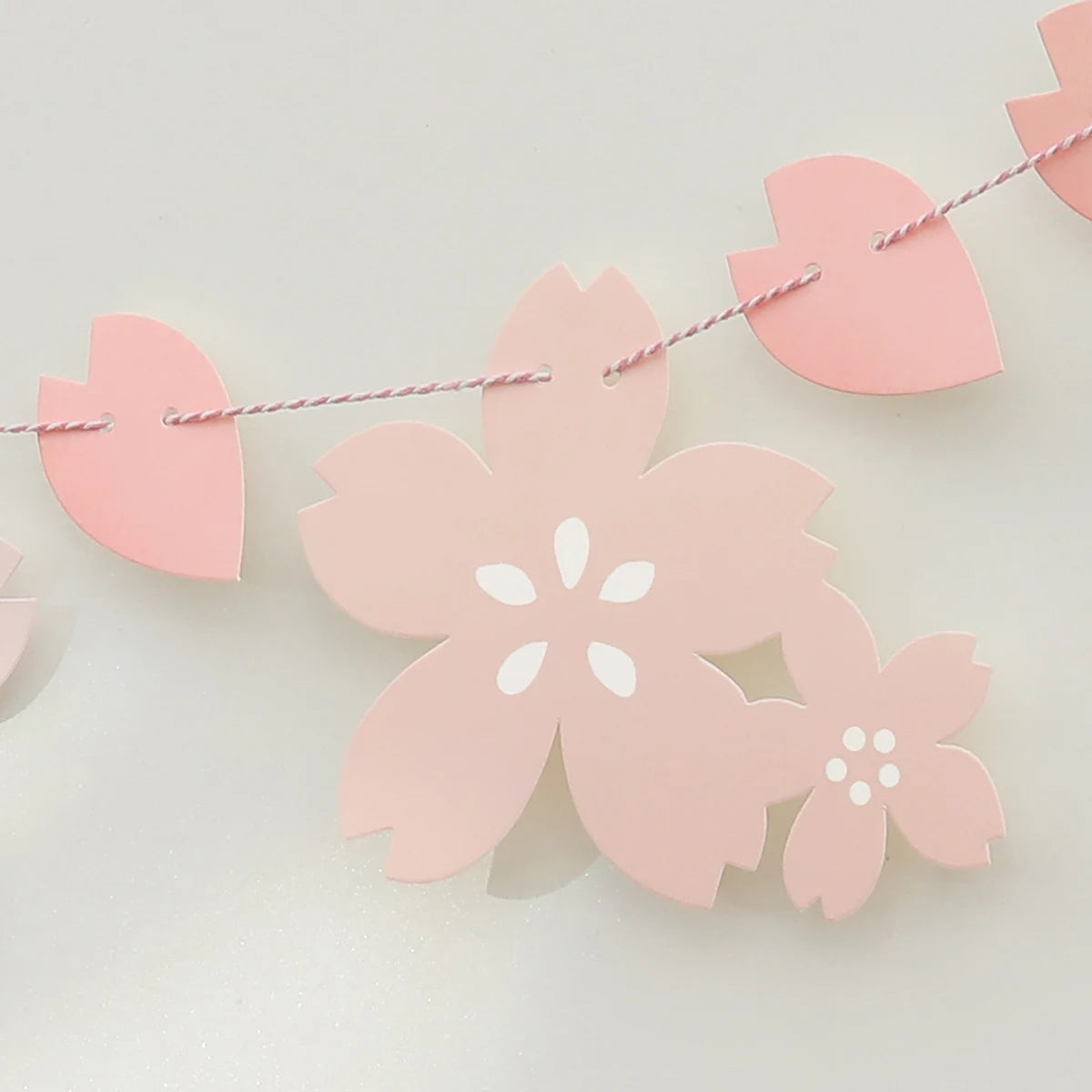 Pink paper cherry blossom flag banner with heart shapes and white flower cutouts