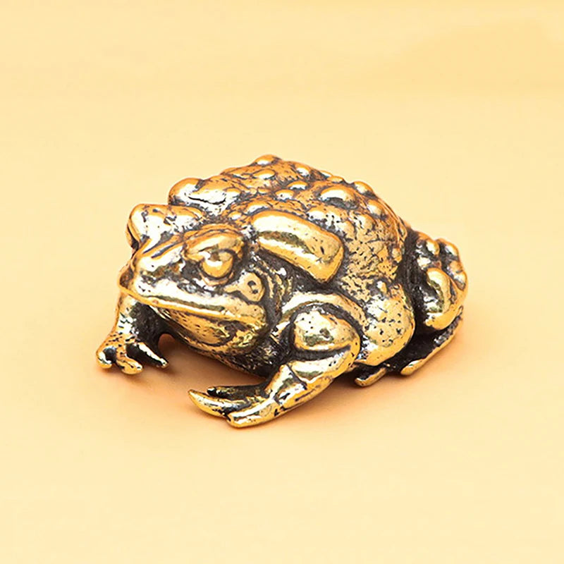 Una pequeña y texturizada figura dorada de una rana usada para la fortuna china.