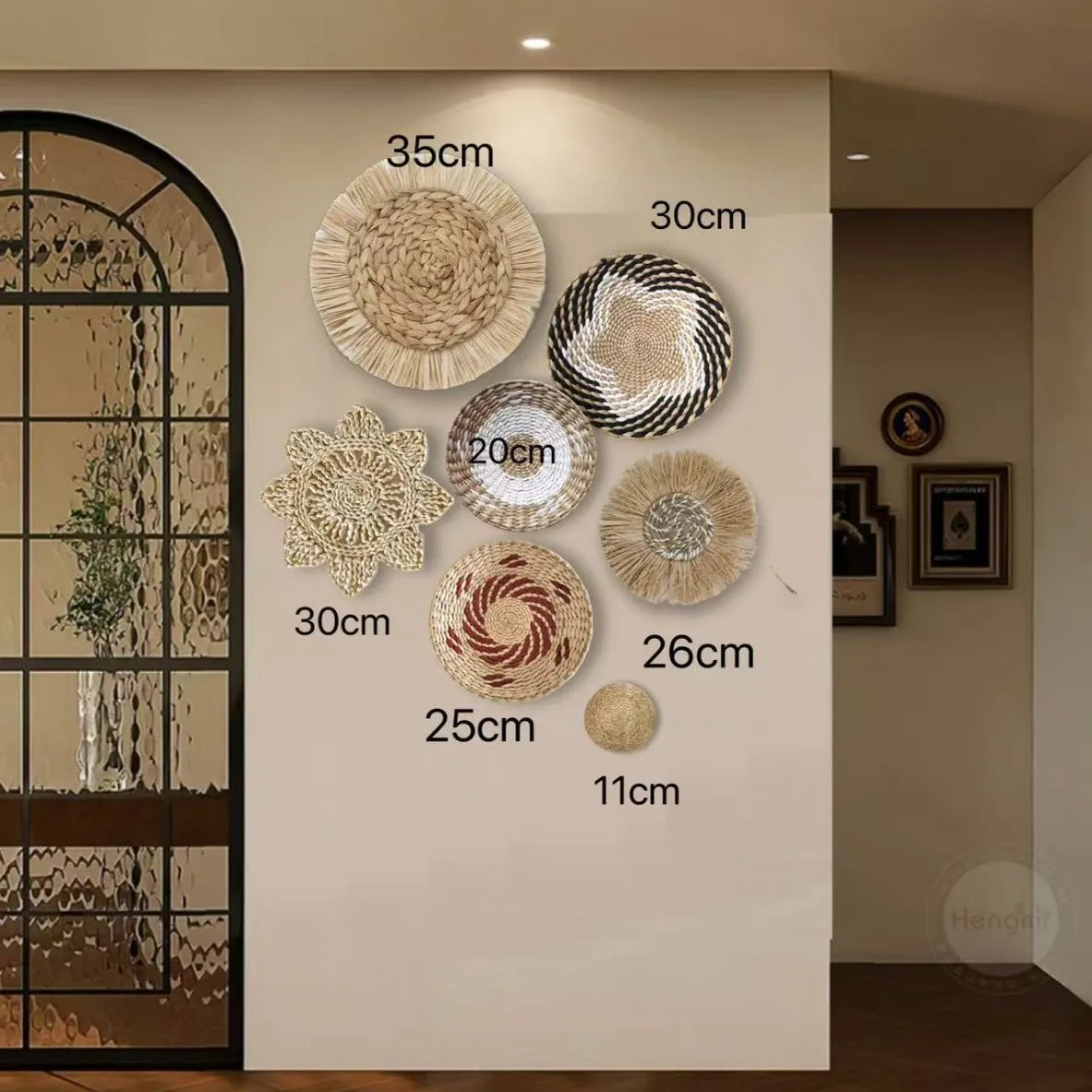 A collection of round boho straw wall hangings with varying diameters displayed on a light-colored wall.