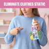 A woman points to an Anti-Static Clothes Spray bottle while wearing a blue sweater, demonstrating its use.