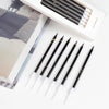 A set of 6 black and gold gradient birthday candles is displayed next to its packaging box.