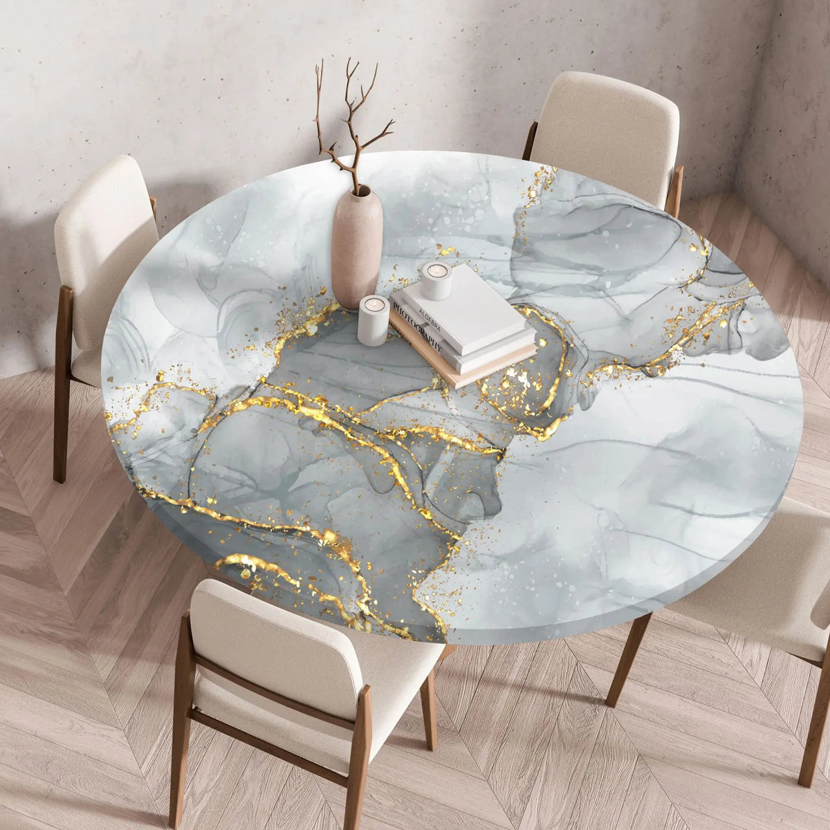 A round table set for dining featuring a marble print tablecloth with gold leaf accents on a light blue and white background.