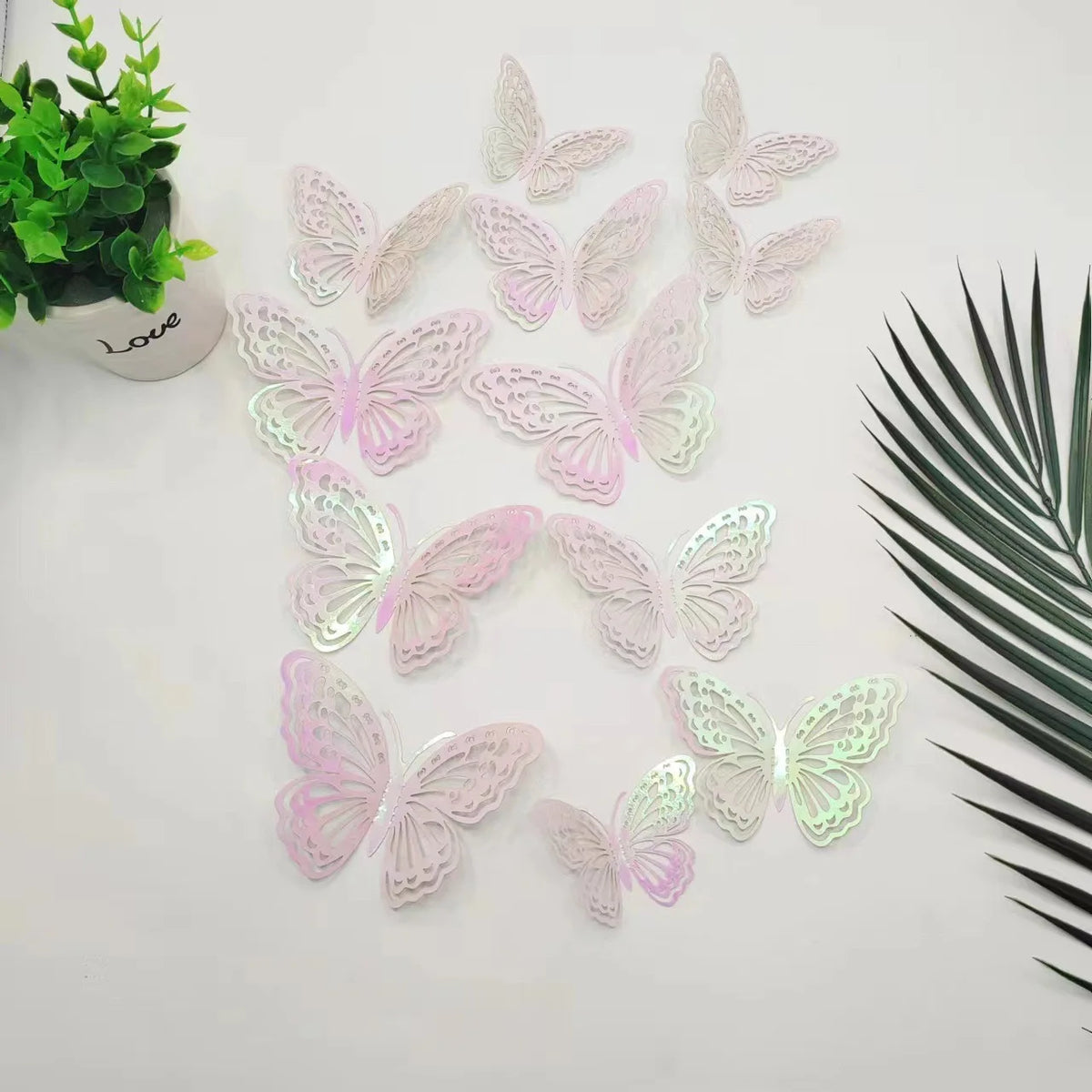 A set of twelve pink and white iridescent 3D butterfly wall stickers displayed on a white surface.