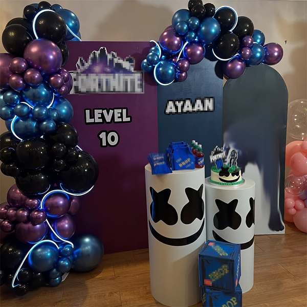 A balloon garland display featuring purple, blue, and black balloons with a sign that reads LEVEL 10
