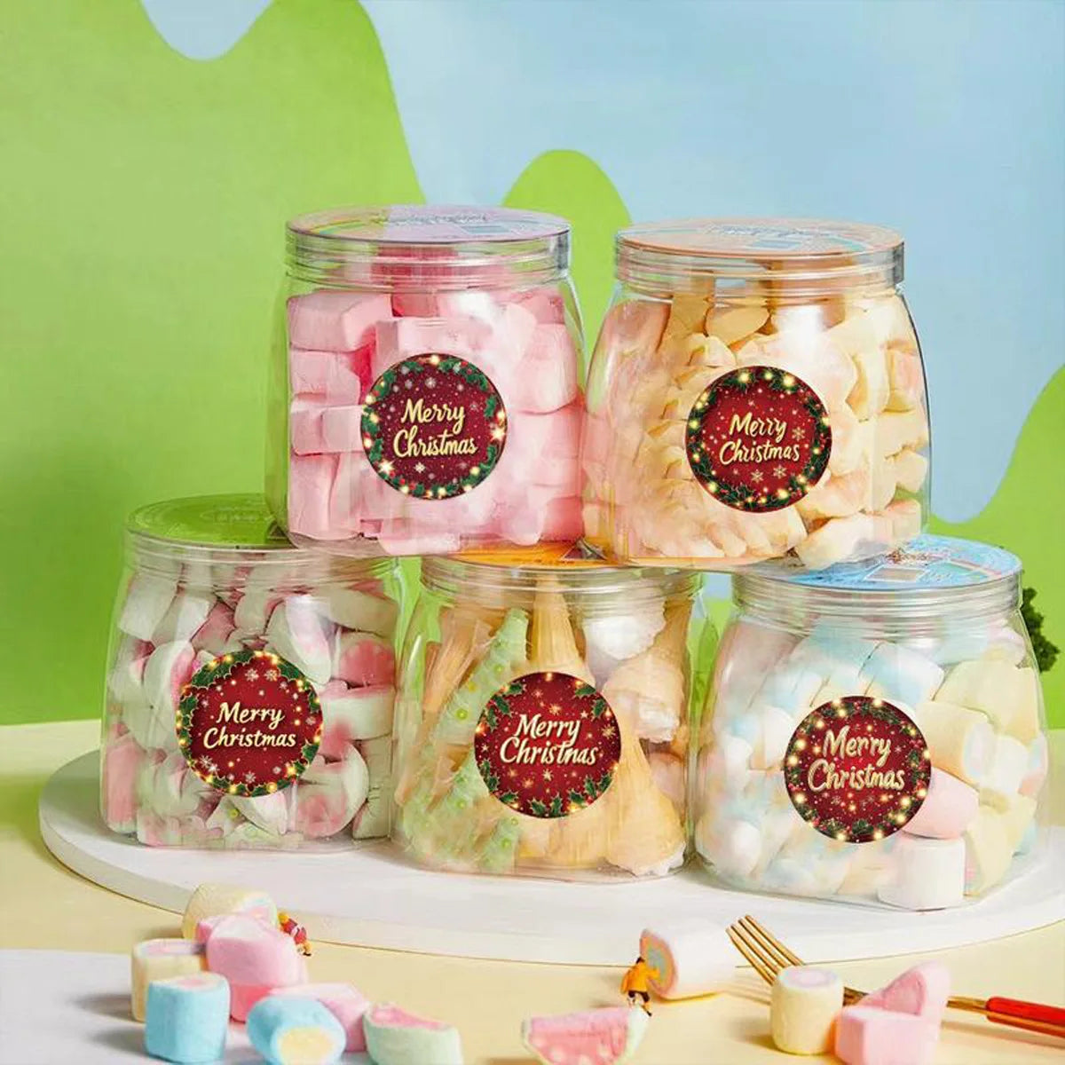 A display of glass jars filled with pink and white festive Christmas wreath stickers for gift wrapping and card decoration
