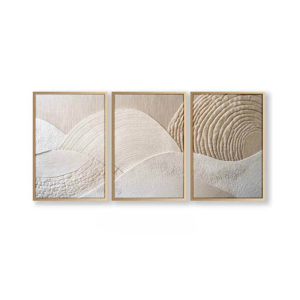 A set of three framed abstract canvas prints featuring beige and white textured mountain shapes.