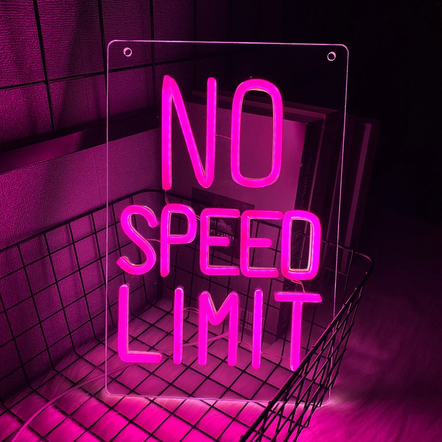 A neon sign displaying NO SPEED LIMIT in bright pink light against a dark background.