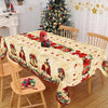 Vintage Christmas tablecloth featuring poinsettia and bell designs on a wooden dining table.
