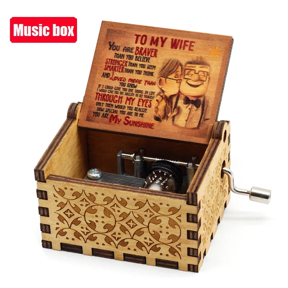 A carved wooden music box with an open lid featuring a vintage-style illustration of a couple.
