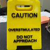 A bright yellow plastic sign with black text warning caution and stating do not approach.