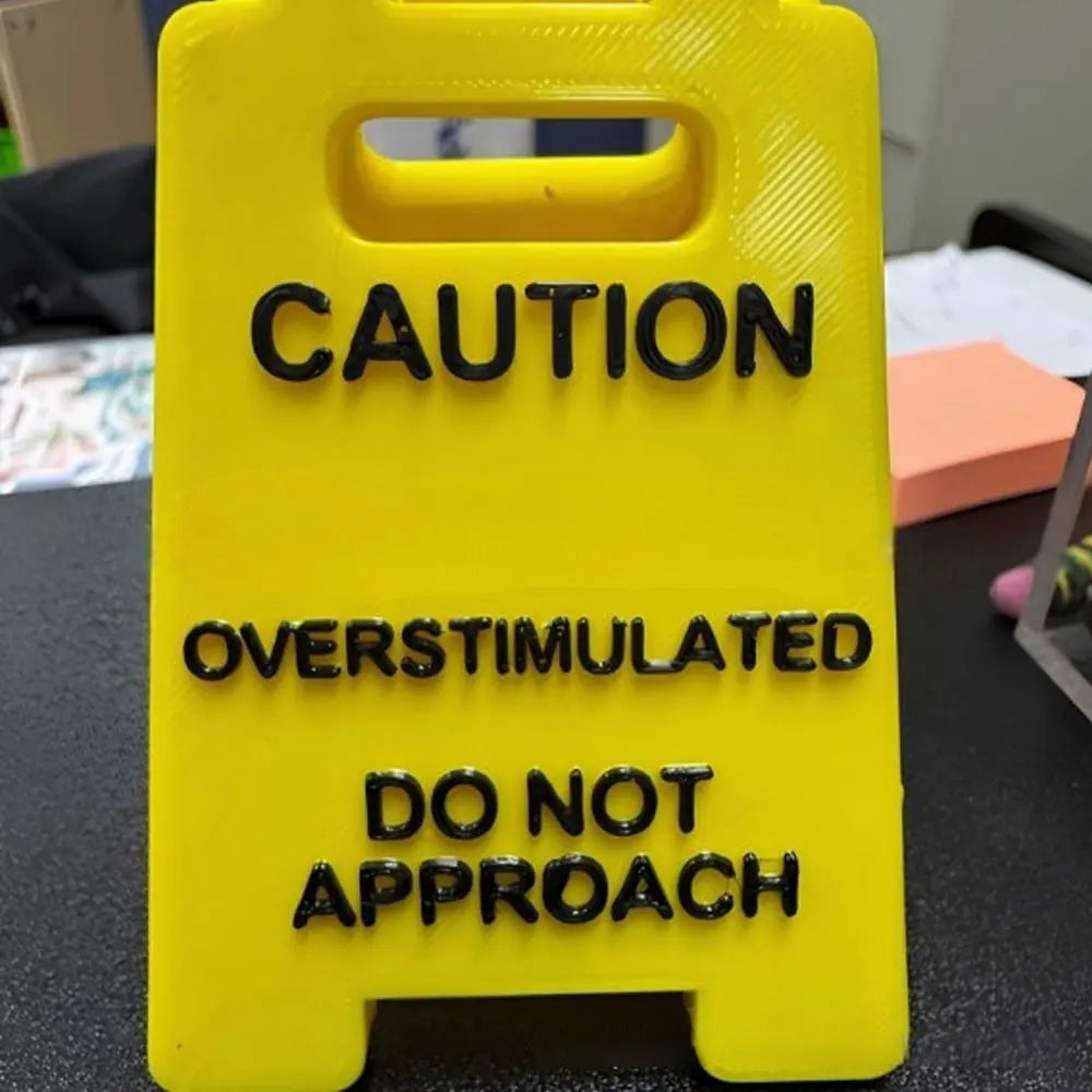 A bright yellow plastic sign with black text warning caution and stating do not approach.