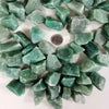 A collection of raw green aventurine crystal stones arranged in a circular pattern.