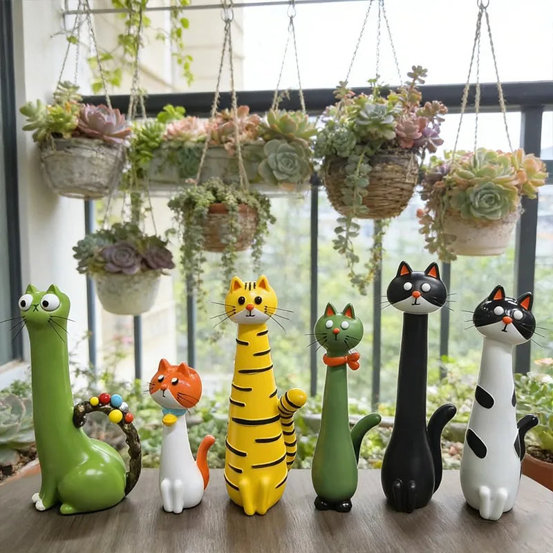 A collection of cat-shaped resin vases in various colors and sizes sitting on a wooden surface.