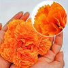 A hand holds a vibrant set of artificial orange marigold and carnation flowers for festive decoration.