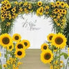 A floral archway decorated with yellow sunflowers framing a walkway.