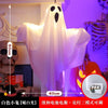 A white ghost-shaped hanging decoration light with a black eye cutout, displayed against a background featuring a skull and s