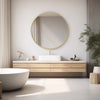 A modern bathroom featuring a light wood vanity with a white vessel sink and a large round mirror with a gold frame.