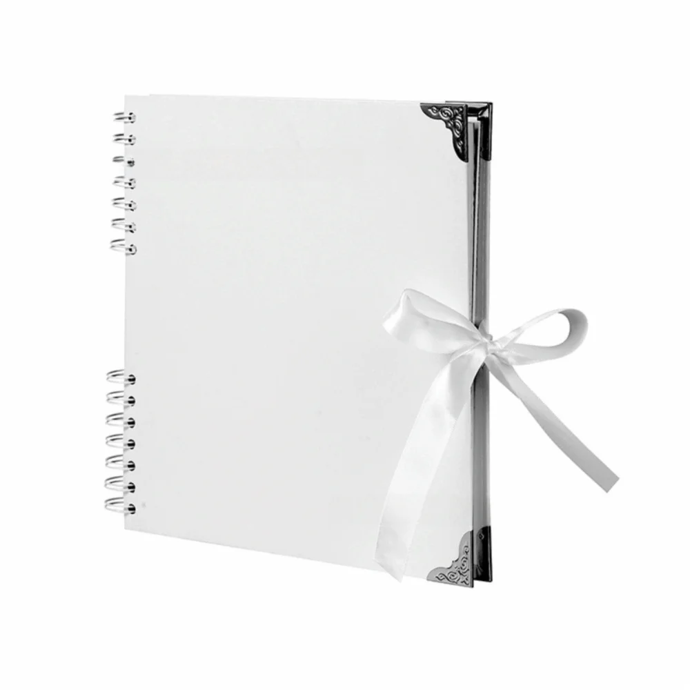 Bloc-notes album photo plat blanc avec fermoir noir décoratif et ruban blanc sur la couverture.